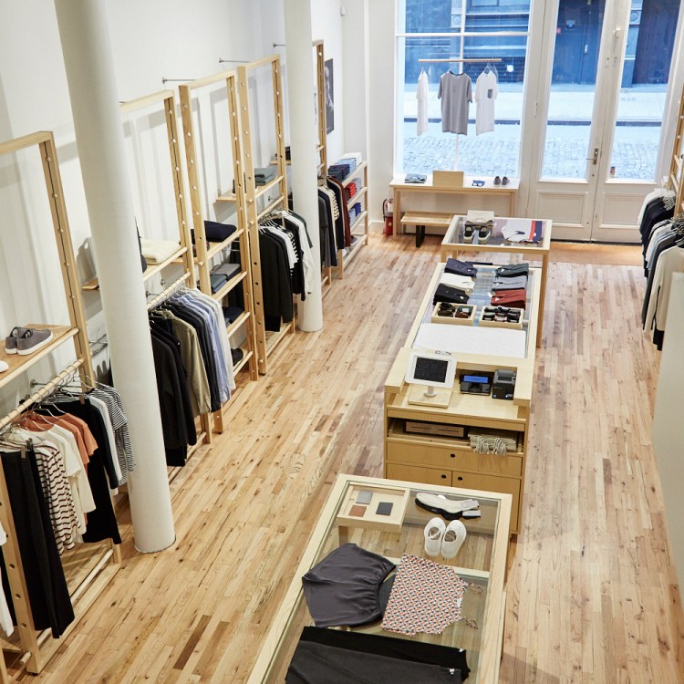 clothes hanging and clothes folded in center, wooden floors, window facing street