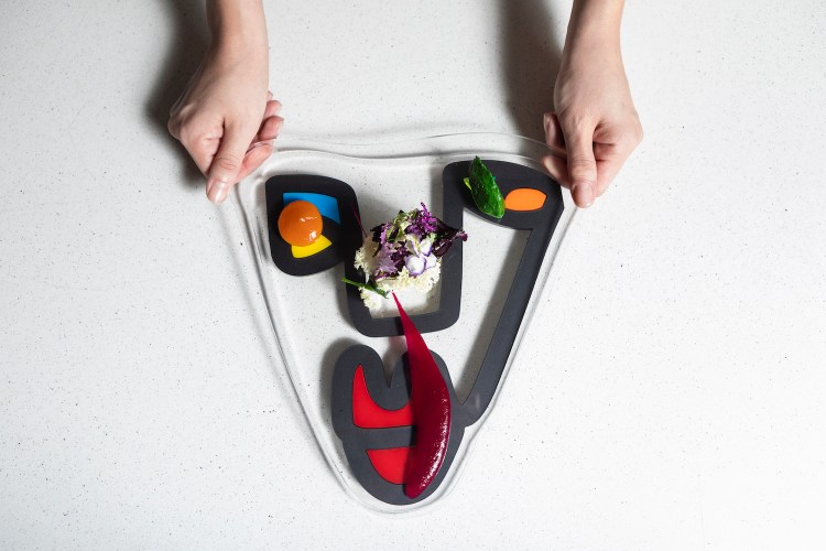 Food being handed out on a platter with flowers in the middle