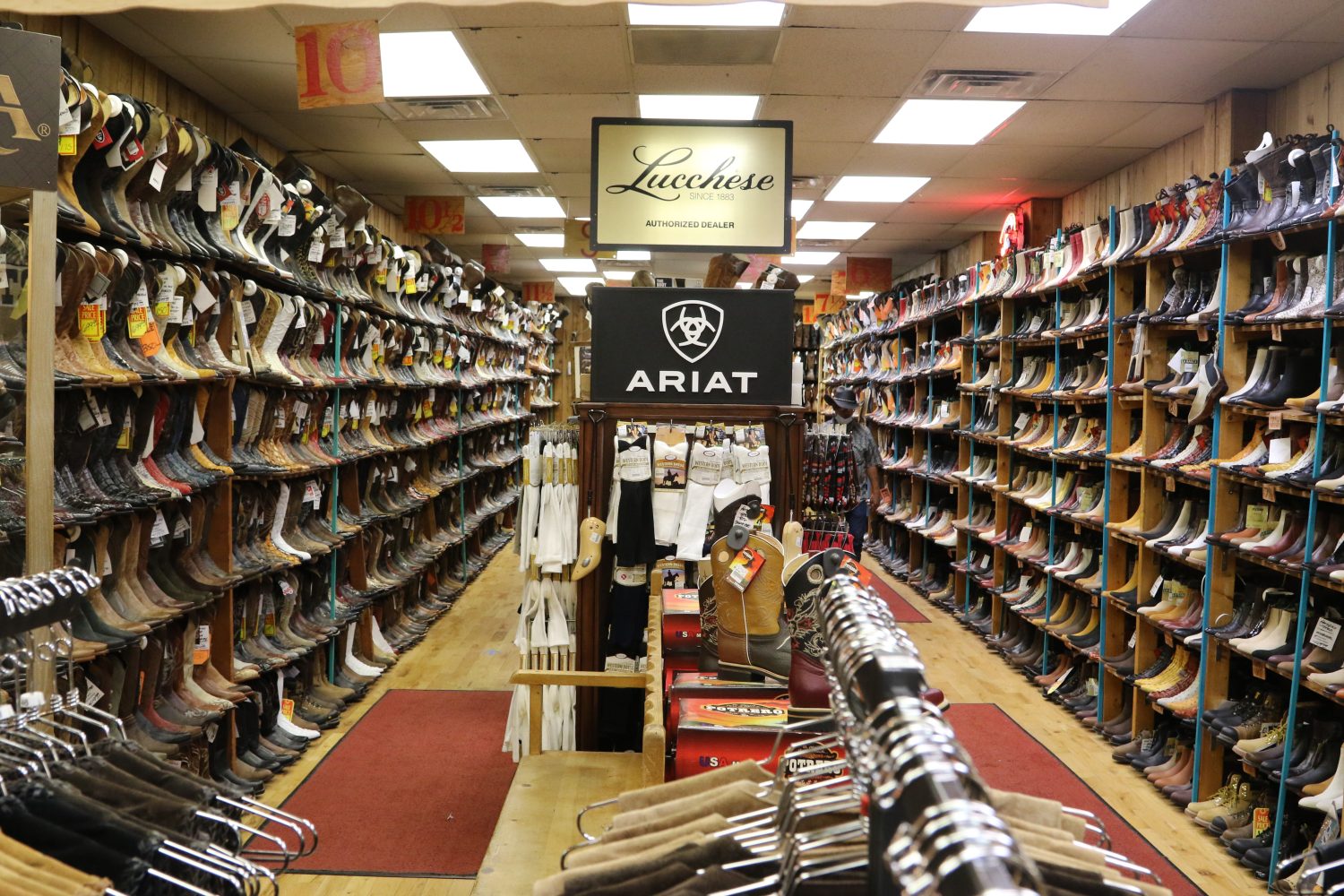 cowboy boots on racks, socks on the middle rack,mirror and sign