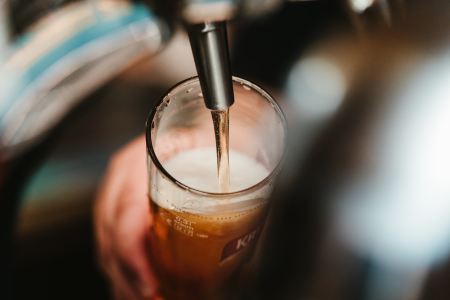 A bartender pouring beer from a tap. Beer sales are down year to year.