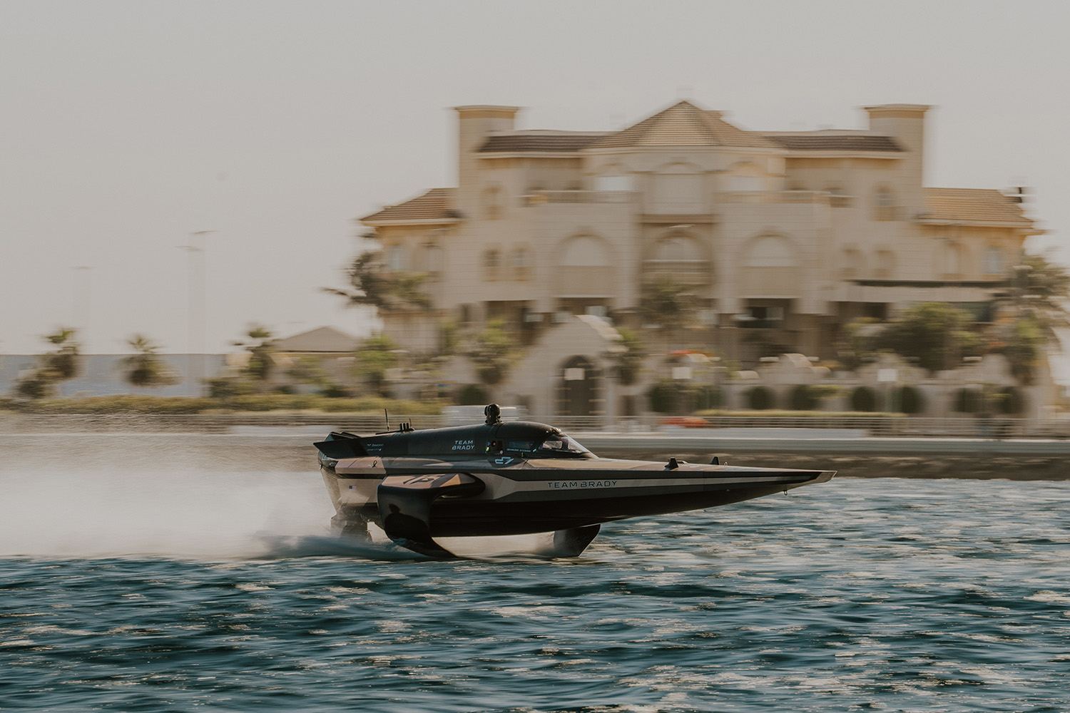 Tom Brady's powerboat team skims across the water.