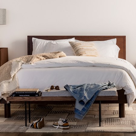 The Burrow Circa Bed with a headboard and a dark walnut finish. The DTC furniture company launched this Bedroom collection in February 2022.