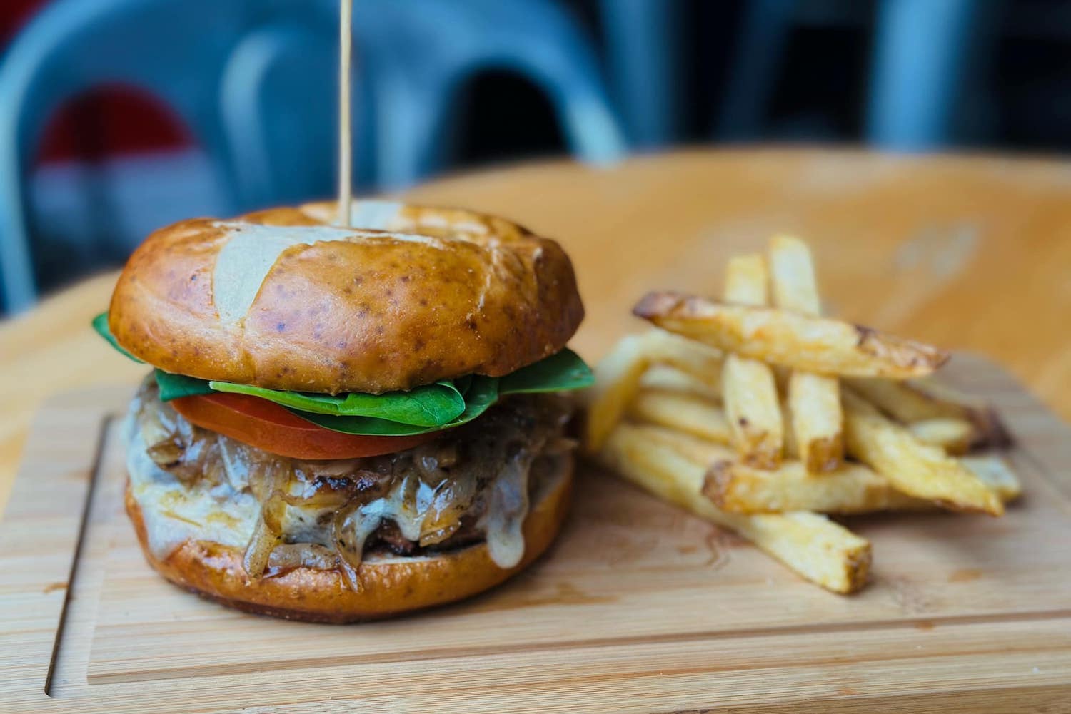 burger with lettuce, tomato, cheese, stick in the middle, side of fries