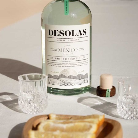 Desolas Mezcal on a table with a glass and orange slices. There's a mezcal for every palate, even if you don't like mezcal.