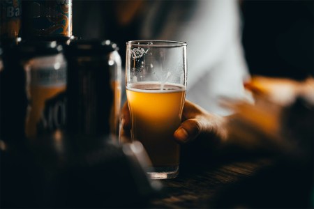 A person drinking a non-alcoholic beer at a bar. NA beer is helping Dry January become a year-round phenomenon.