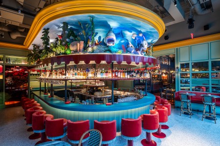 Blue and red bar area with neon colors and dim lighting with scenic ocean design on top of the bar