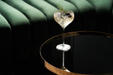 Classic cocktail glass on glass table in night club restaurant, close-up