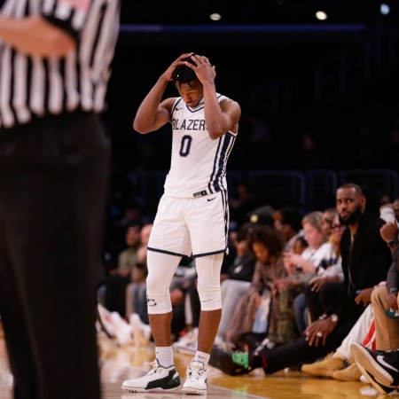 Bronny James playing basketball as father LeBron looks on