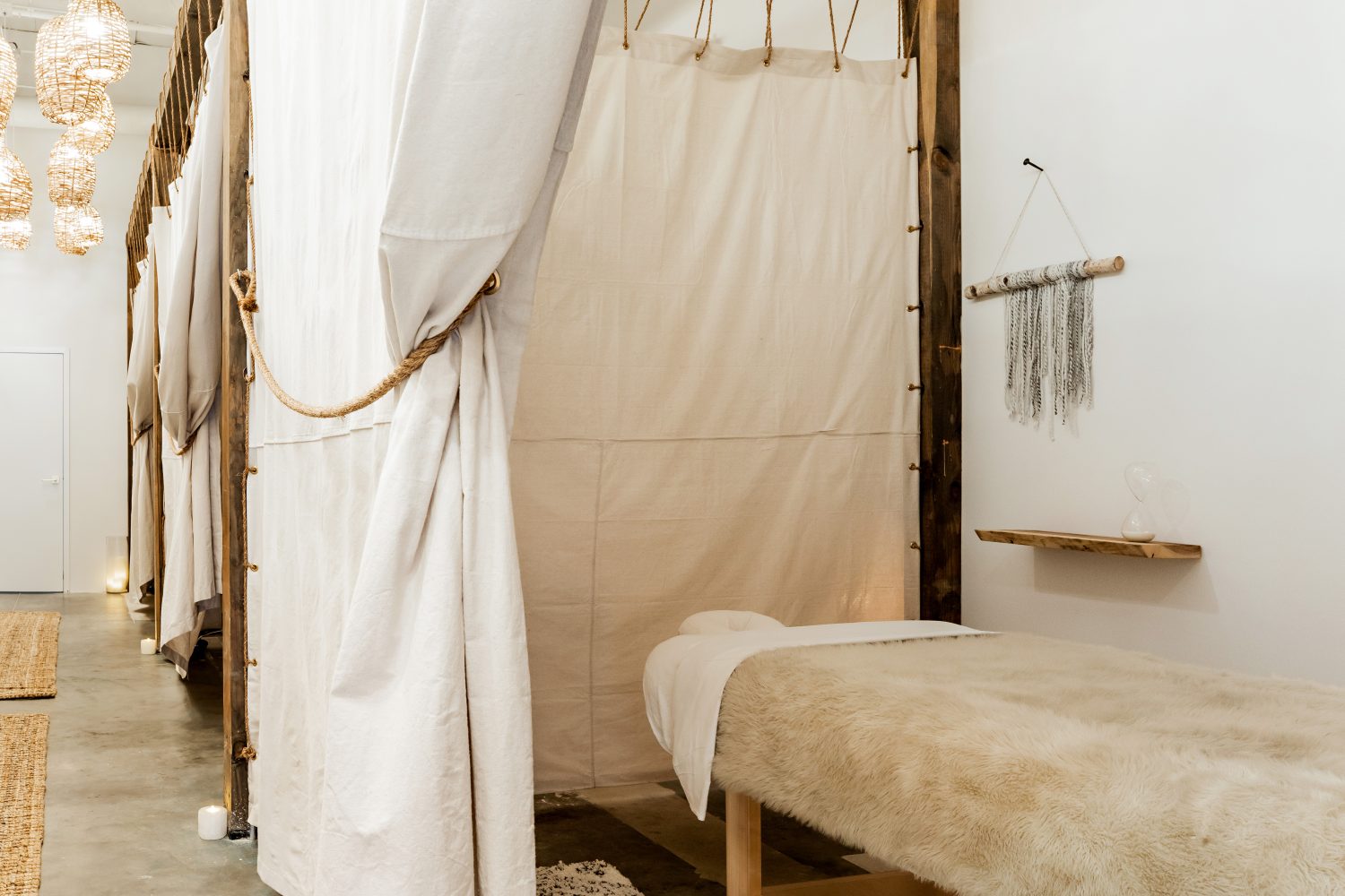 white massage table, dream catcher on wall, white curtain