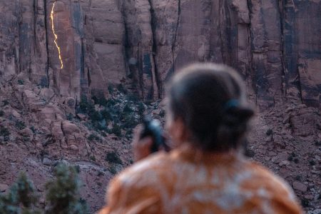 Photographer Krystle Wright takes stationary images of her lighting design on a Long Canyon cliff face.