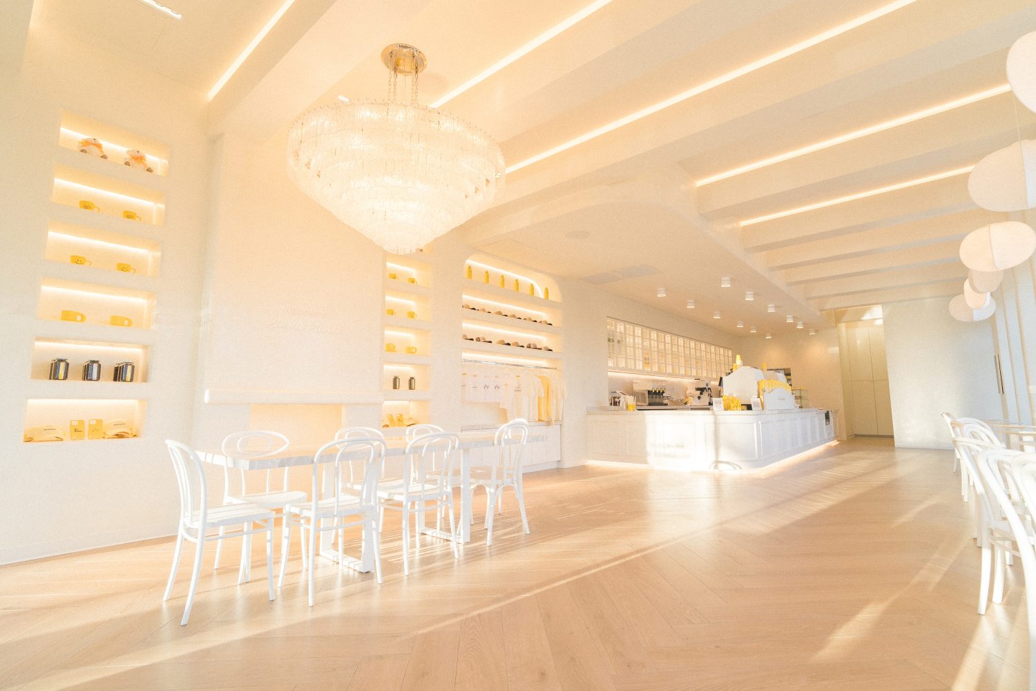 bright room with all white furniture and chandelier