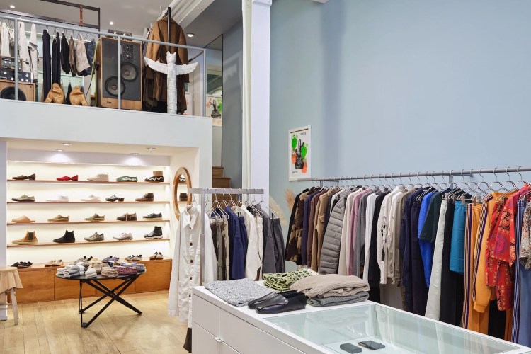 Inside of Mohawk Man with clothes hanging on racks and on display in tables and on shelves