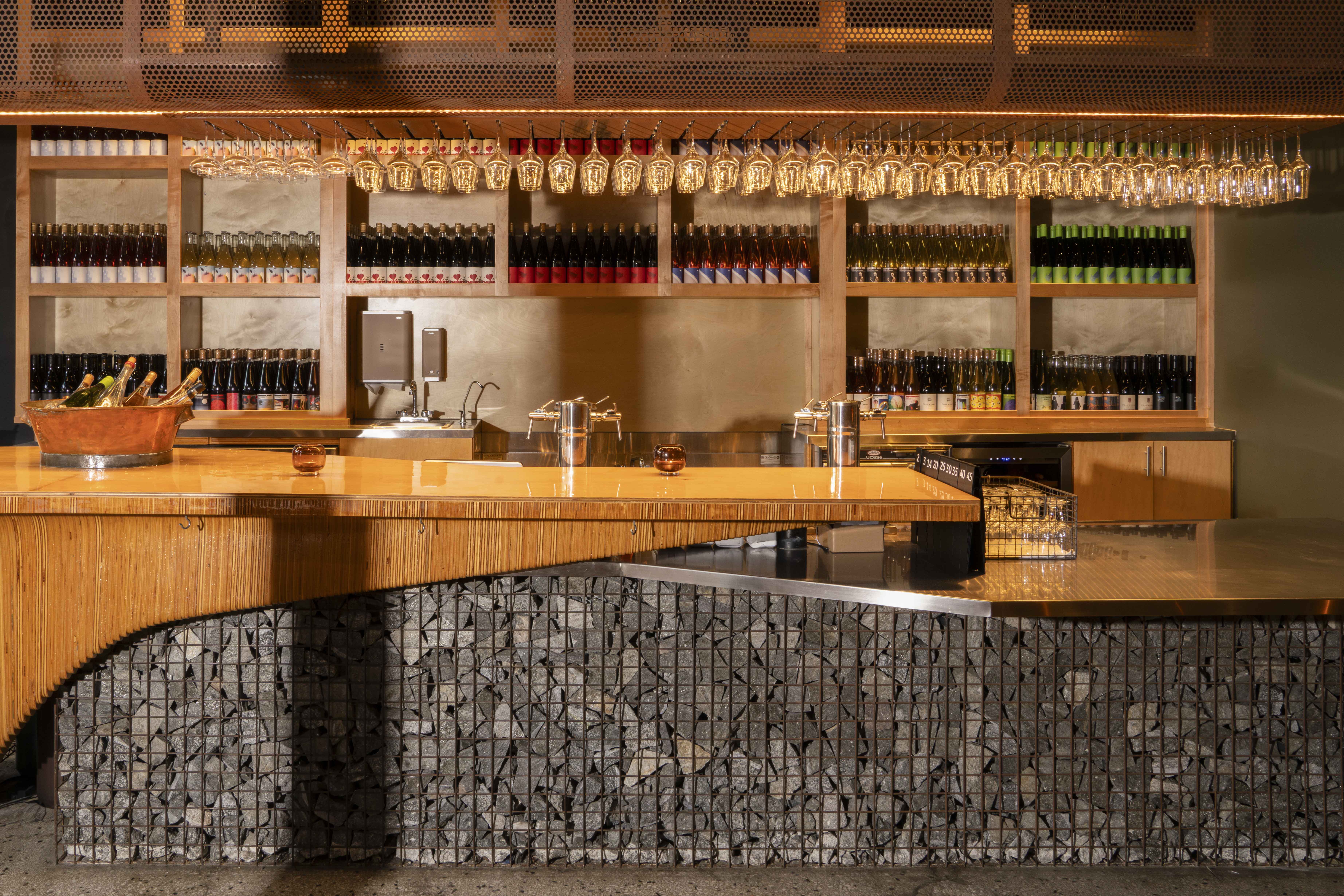 wooden bar with glasses hanging and alcohol on shelves