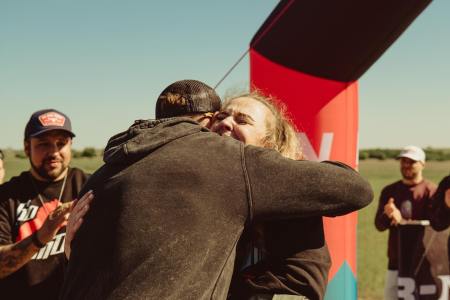 Nick Bare hugging a runner at the finish line.