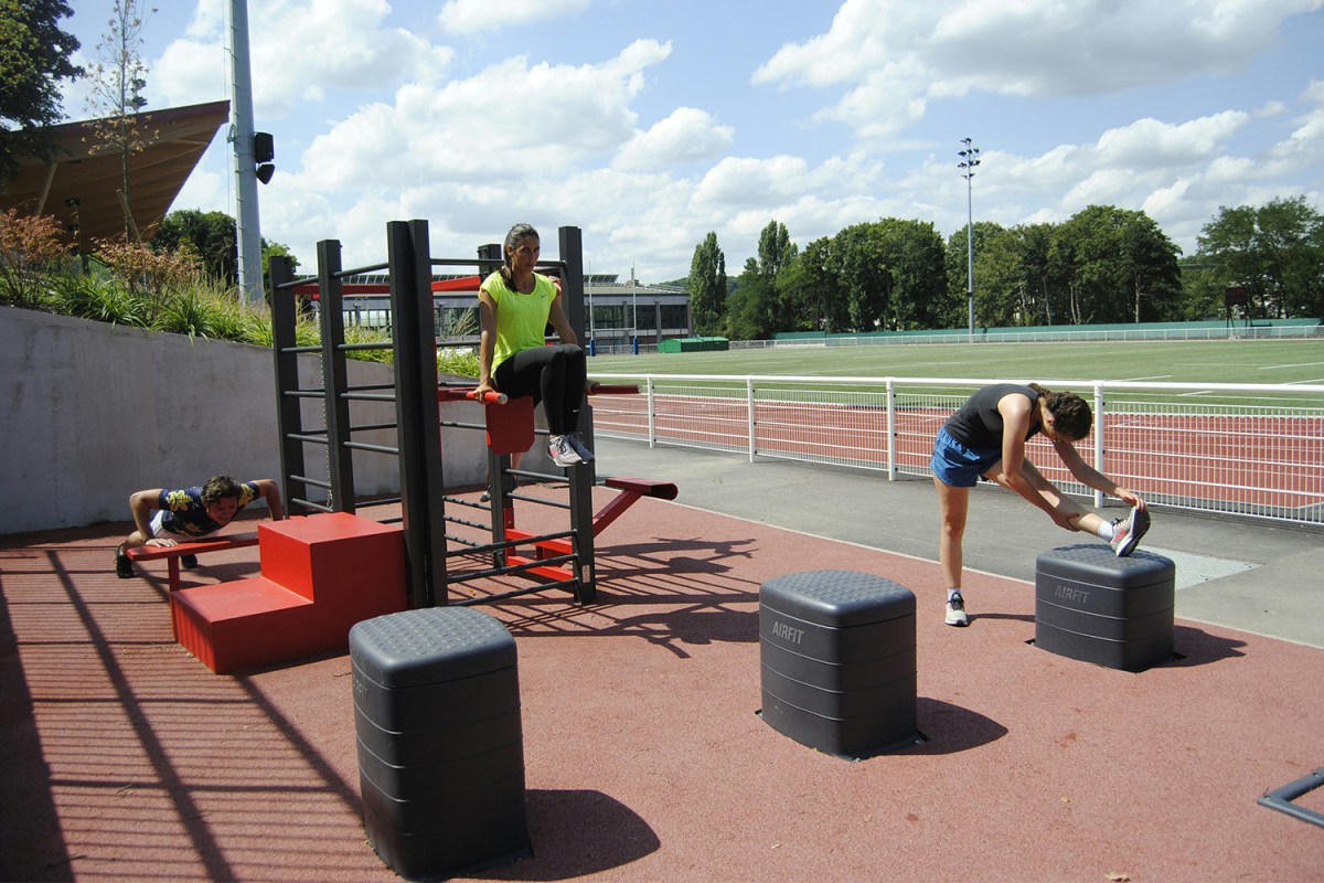 A group of people exercising at an outdoor fitness park.