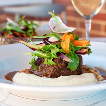 mashed potatoes in gravy with meat and vegetables piled on top