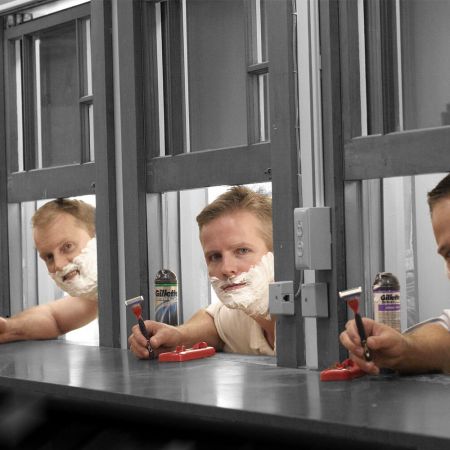 A line of men testing out wet-shave razors at separate stations. We're looking at the men's shaving industry, which hasn't created any significantly new designs in decades.