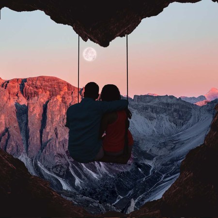 A couple sitting i a cave outpost on a mountain that looks like a heartr. It's not always rainbows and butterflies when you travel with a partner.