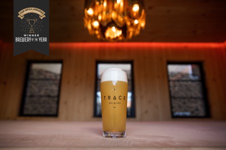 a beer on a wood table under a chandelier