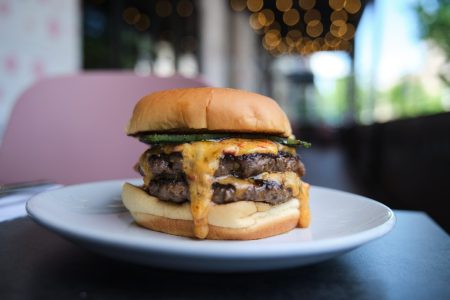 burger with two beef patties, melted cheese, and lettuce