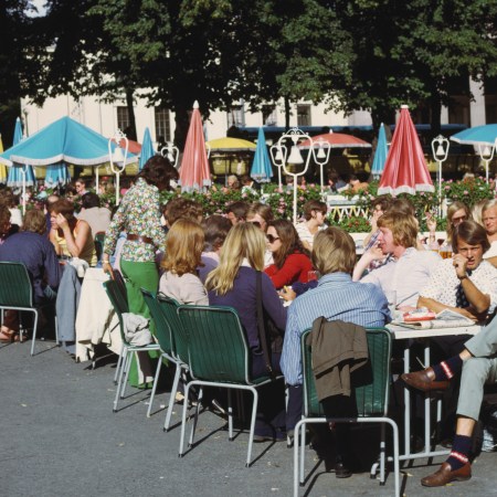 A group of Germans drinking beers at a cafe outside.