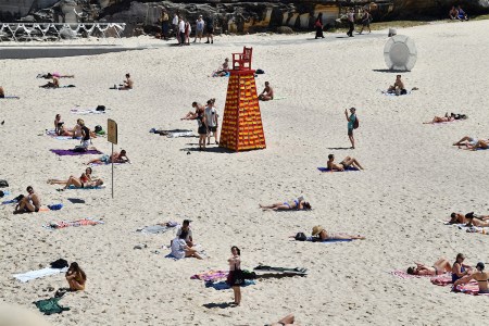 A bunch of people lying around on a beach.