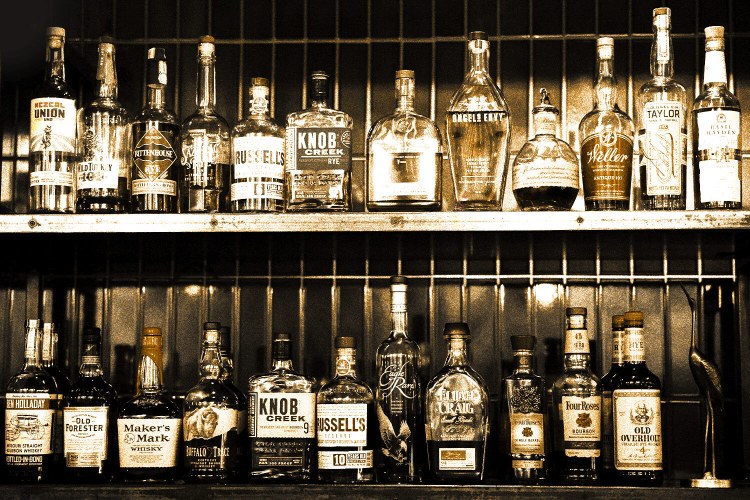 A collection of various whiskey and booze bottles in a liquor store. "Dusty hunters" will score these stores for deals on vintage or overlooked rare bottles.