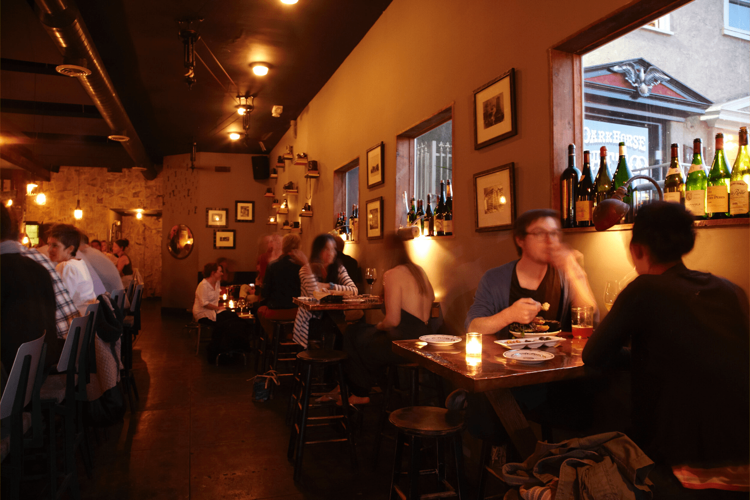 people sitting at tables conversing, candles