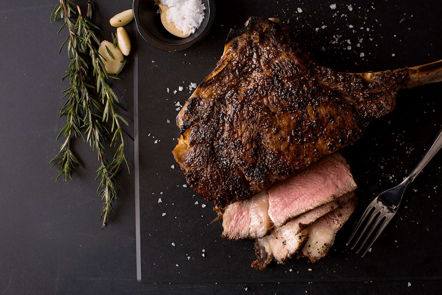 steak cut up with herbs on the side, knife 