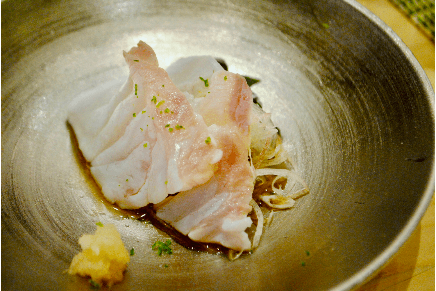 two pieces of sashimi on a golden plate